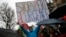 A protester holds a banner reading " Stop of state of emergency" during a protest in Paris, Jan. 30, 2016.