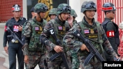 FILE - Soldiers patrol around the Royal Thai Army Headquarters as members of the Radio and Satellite Broadcasters gather in Bangkok, June 18, 2014. 