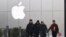 FILE - Men walk past an Apple logo in Beijing, China, Jan. 3, 2019.