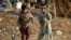 Children play with puppies at an Afghan refugee camp in Islamabad, Pakistan, Feb. 2, 2018.