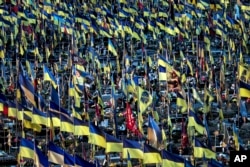 Banderas nacionales ucranianas ondean sobre cientos de tumbas de militares ucranianos muertos en combates desde la invasión rusa, en Járkov, Ucrania, el jueves 6 de junio de 2024. (Foto AP/Evgeniy Maloletka)