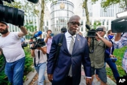 R. Kelly's attorney Deveraux Cannick is surrounded by reporters as he leaves U.S. District Court in Brooklyn during the R&B star's trial, in New York, Aug. 18, 2021.