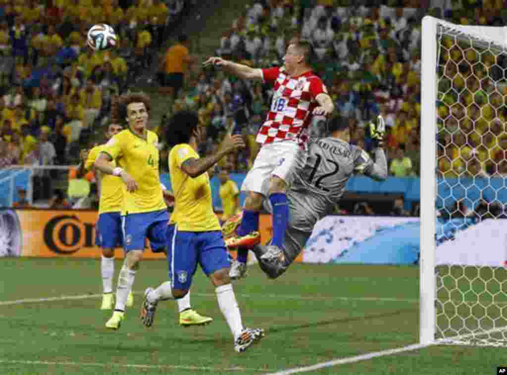 Pemain Kroasia Ivica Olic mengelabui penjaga gawang Brazil Julio Cesar dalam pertandingan pembukaan dari grup A, di Stadion Itaquerao, Sao Paulo, Brazil (12/6). Kroasia kalah 1-3. (AP/Kirsty Wigglesworth)