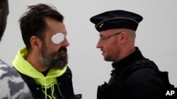 Yellow vest protester, Jerome Rodrigues, left, walks out of the Court as Eric Drouet, a prominent and divisive figure of the yellow vest movement, went on trial for organizing an unauthorized demonstration, in Paris, Friday, Feb. 15, 2019. 