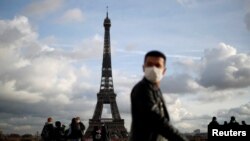 TƯ LIỆU: Một người đeo khẩu trang bước đi trên quảng trường Trocadero gần Tháp Eiffel ở Paris, Pháp, ngày 22 tháng 1, 2021. 