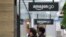 Two people wearing masks walk near an Amazon Go store in downtown Seattle, April 30, 2020.