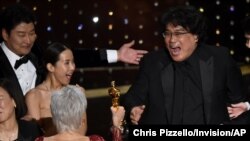 Bong Joon Ho, right, reacts as he is presented with the award for best picture for "Parasite" from presenter Jane Fonda at the Oscars, Feb. 9, 2020, at the Dolby Theatre in Los Angeles, California.