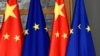 FILE - European Union and Chinese flags are displayed at the Europa building in Brussels, Dec. 17, 2019. 