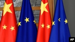 FILE - European Union and Chinese flags are displayed at the Europa building in Brussels, Dec. 17, 2019. 