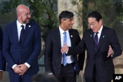 European Council President Charles Michel, left, British Prime Minister Rishi Sunak, center, and Japanese Prime Minister Fumio Kishida speak during the G7 summit on June 14, 2024, in Borgo Egnazia, Italy.