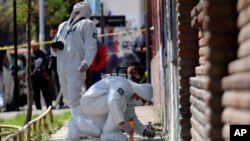 Peritos buscan evidencia en el lugar donde explotó una bomba en Santiago la madrugada del jueves.