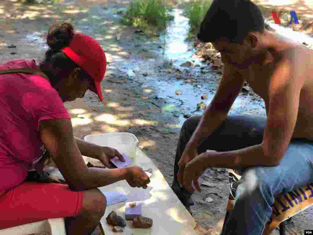 Un hombre y una mujer juegan carta en el refugio improvisado&nbsp;creado por venezolanos en el vecindario Jardim Floresta, fronterizo de Brasil. Foto: Celia Mendoza - VOA