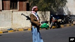 An armed Houthi Shi'ite Yemeni stands guard outside the Republican Palace in Sana'a, Feb. 16, 2015.