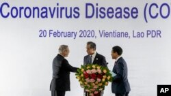 China's Foreign Minister Wang Yi, center, talks with Philippines Foreign Affaires Secretary Teodoro Locsin Jr., left and Laos Foreign Minister Saleumxay Kommasith following a meeting on the Novel Coronavirus Pneumonia in Vientiane, Laos, Feb. 20, 2020.