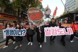 FILE - Protesters march to oppose the United States' demand for raising the defense costs for stationing U.S. troops in South Korea, in Seoul, South Korea, Nov. 16, 2019.
