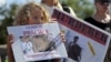 Protesters hold signs during a rally outside the River Bluff Dental clinic against the killing of a famous lion in Zimbabwe, in Bloomington, Minnesota, July 29, 2015. 