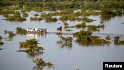 A barge transports vehicles across the River Niger channel in Lokoja, Kogi State, following flooding along the River Niger and Benue confluence in central Nigeria, Sept. 24, 2012.