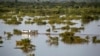 A barge transports vehicles across the River Niger channel in Lokoja, Kogi State, following flooding along the River Niger and Benue confluence in central Nigeria, Sept. 24, 2012.