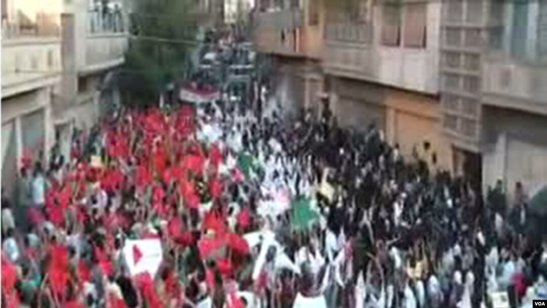 Unjuk rasa ribuan demonstran anti-pemerintah di kota Homs (18/9).