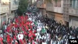 Unjuk rasa ribuan demonstran anti-pemerintah di kota Homs (18/9).