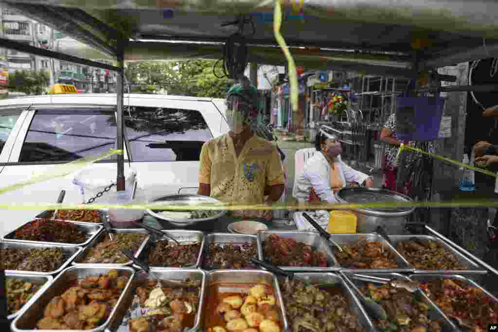 ကိုရိုနာဗိုင်းရပ်စ် ကူးစက်ပျံ့နှံ့မှု တိုးနေတဲ့ ရန်ကုန်မြို့မှာ နှာခေါင်းစည်းတပ်ပြီး အစားအစာ ရောင်းချနေသူတဦး။ (စက်တင်ဘာ ၁၁၊ ၂၀၂၀)