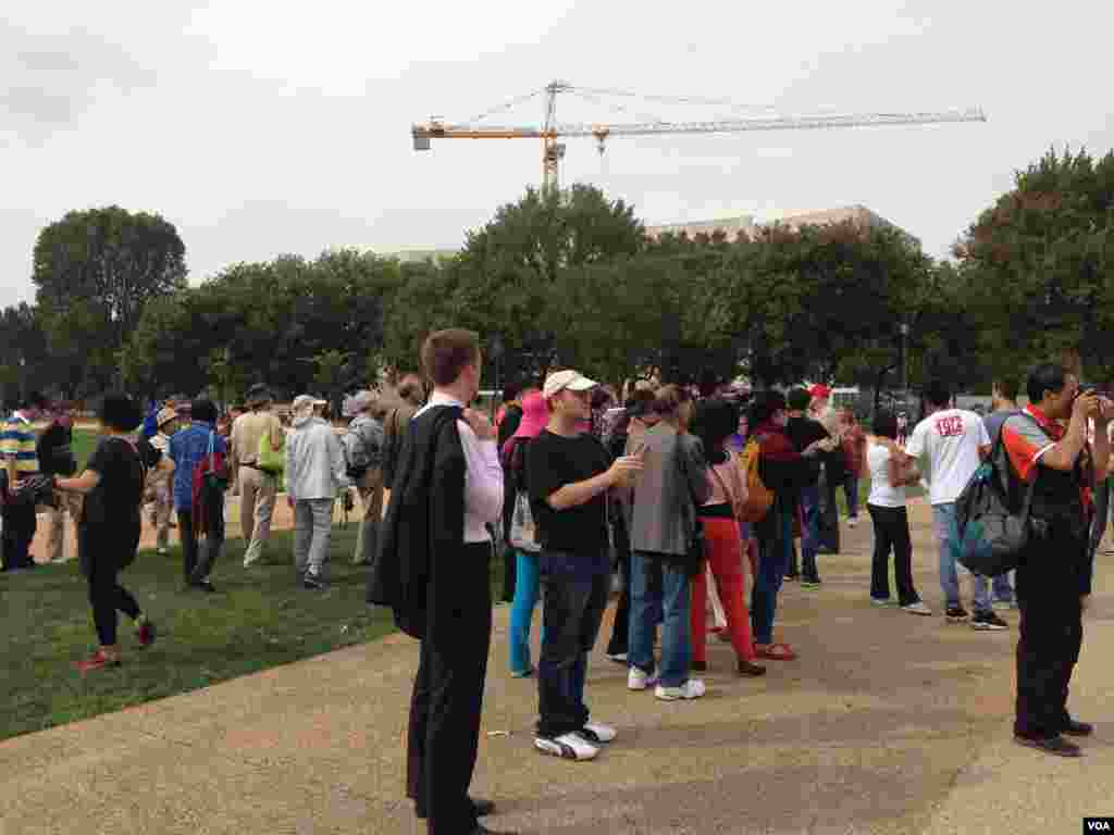 Turis mengerumuni taman National Mall dekat gedung Capitol, setelah terjadinya penembakan (Sandra Lemaire/VOA).