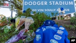 Se colocan flores y recuerdos en el exterior del Dodger Stadium tras la muerte del ex lanzador de los Dodgers Fernando Valenzuela, el miércoles 23 de octubre de 2024, en Los Ángeles. (Foto AP/Damian Dovarganes).