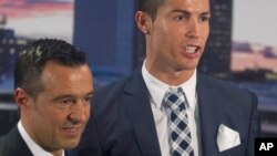 L'attaquant du Real Madrid, Cristiano Ronaldo, pose avec son agent Jorge Mendes après avoir reçu un trophée de bottine d'argent pour avoir marqué le plus de buts pour le club lors d'une cérémonie au stade Santiago Bernabeu à Madrid, en Espagne, 2 octobre 