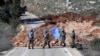 UN peacekeepers hold their flag in Blida, a Lebanese border village with Israel, in south Lebanon, Jan. 25, 2025. 