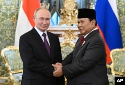 FILE - Presiden Rusia Vladimir Putin (kiri) dan Menteri Pertahanan Indonesia sekaligus Presiden Terpilih Prabowo Subianto berjabat tangan pada pertemuan mereka di Kremlin di Moskow, Rusia, 31 Juli 2024. (Grigory Sysoyev, Sputnik, Kremlin Pool Photo via AP)