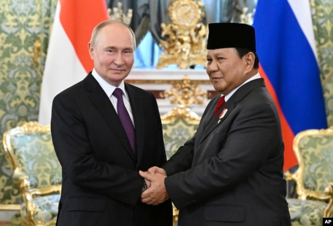 FILE - Presiden Rusia Vladimir Putin (kiri) dan Menteri Pertahanan Indonesia sekaligus Presiden Terpilih Prabowo Subianto berjabat tangan pada pertemuan mereka di Kremlin di Moskow, Rusia, 31 Juli 2024. (Grigory Sysoyev, Sputnik, Kremlin Pool Photo via AP)