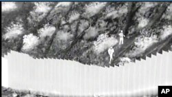 Captura de pantalla de un video de la Oficina de Aduanas y Protección Fronteriza de EE. UU., muestra el momento en que traficantes lanzan a dos niñas desde lo alto del muro fronterizo con México en Santa Teresa, Nuevo México, el 30 de marzo de 2021.