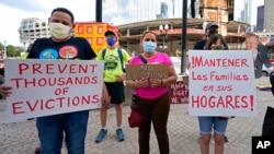Ljudi drže transparente tokom okupljanja u znak protesta zbog iseljavanja iz kuća, u Bostonu, 9. juna 2021.