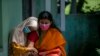 A physically disabled Nepalese girl waits with her mother to receive a dose of Johnson and Johnson vaccine at the Nepal Disabled Association Khagendra New Life Center in Kathmandu.