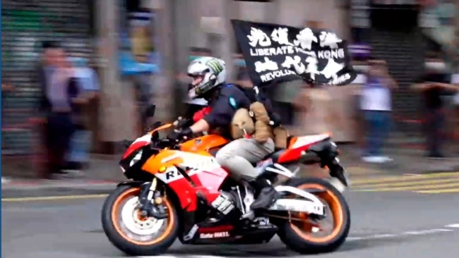 FILE - Motorcyclist Tong Ying-kit carries a flag reading