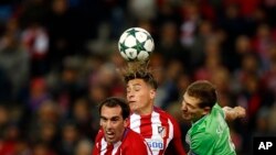 José Maria Gimenez d'Atletico, au centre, saute avec son coéquipier Diego Godin, à gauche, et le Daniel Schwaab du PSV, en lutte pour le ballon, lors d'un match de football du Groupe D entre l'Atlético de Madrid et le PSV Eindhoven au stade Vicente Calder