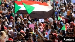 Sudanese protesters and wave flags during a rally at the Green Square in Khartoum, Sudan, July 18, 2019. 