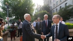 New York Times lawyer David McCraw, left, shakes hands with New York Times Publisher A.G. Sulzberger, after a meeting with Attorney General Merrick Garland at the Department of Justice, June 14, 2021, in Washington.