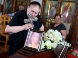 The mother of Livia Florentina Bunea of Romania leans over to kiss a cross during the funeral of Bunea, 36, and her 8-year-old daughter, Elena Natalia, in Arediou, Cyprus, June 13, 2019. The pair are believed to have been victims of a serial killer.