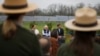 FILE - Former President Jimmy Carter, center, sits with his grandson Jason Carter, left, and George Mori, executive vice president at SolAmerica Energy during a ceremony for a solar panel project on Jimmy Carter's farmland in his hometown of Plains, Ga., Feb. 8, 2017.