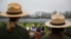 FILE - Former President Jimmy Carter, center, sits with his grandson Jason Carter, left, and George Mori, executive vice president at SolAmerica Energy during a ceremony for a solar panel project on Jimmy Carter's farmland in his hometown of Plains, Ga., Feb. 8, 2017.