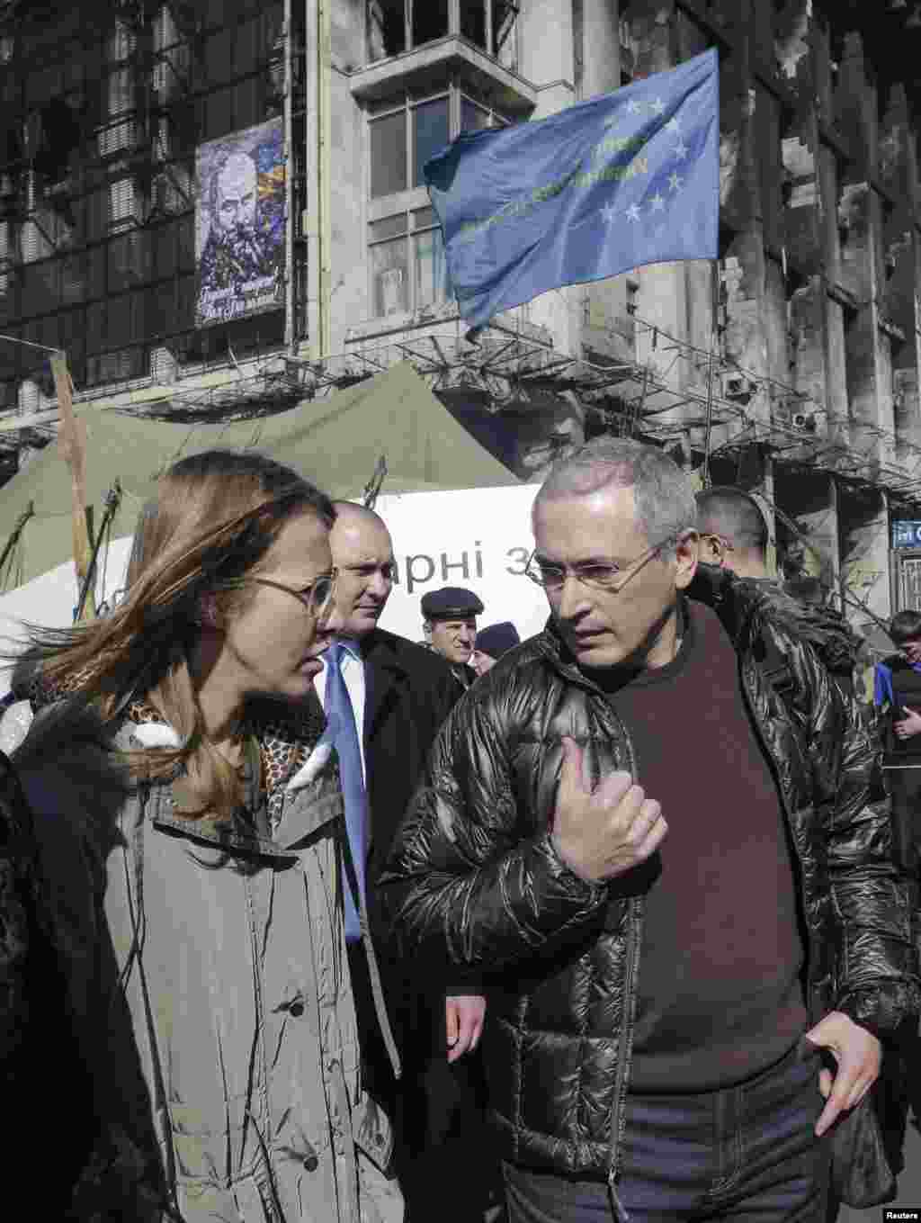 Former Russian oil tycoon Mikhail Khodorkovsky (R) and Russian opposition activist Ksenia Sobchak visit Independence Square, cradle of the uprising against ousted President Viktor Yanukovuch, in Kyiv, March 9, 2014.