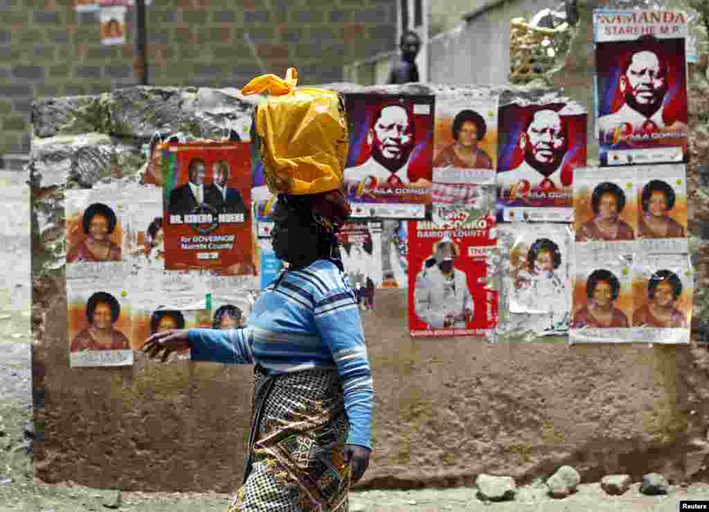Une femme passant devant des affiches électorales à Nairobi, le 3 mars 2013.