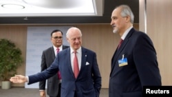 The United Nations Special Envoy for Syria, Staffan de Mistura (C) welcomes Bashar al-Jaafari, Syrian U.N. Ambassador, prior to a round of negotiations during the Intra Syria talks, at the European headquarters of the United Nations in Geneva, Switzerland