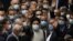 President Ebrahim Raisi, center, waves to journalists as he is surrounded by group of lawmakers after taking his oath as president at the parliament in Tehran, Iran, Aug. 5, 2021.