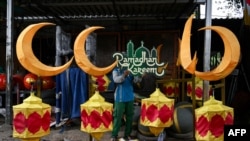 Seorang pekerja sedang menyiapkan hiasan-hiasan untuk menyambut bulan suci Ramadan di Surabaya, 20 Februari 2025. (Foto: Juni Kriswanto/AFP)