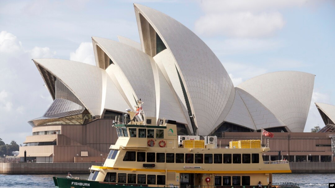 Sebuah kapal feri berlayar melewati Opera House di Sydney, Australia, Selasa, 6 April 2021. (AP Photo/Rick Rycroft)