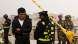 A police officer checks the identity card of a man as security forces keep watch in a street in Kashgar, Xinjiang Uighur Autonomous Region, China, March 24, 2017. 