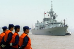 FILE - Chinese seamen stand as they welcome the arriving Canadian Navy Frigate, HMCS Regina in the port of Shanghai, Aug. 15, 2006.