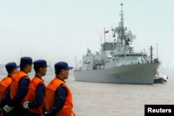 FILE - Chinese seamen stand as they welcome the arriving Canadian Navy Frigate, HMCS Regina in the port of Shanghai, Aug. 15, 2006.